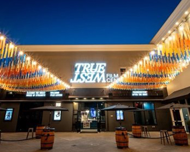 True West Film Center front entrance lit up in the evening.